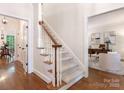 Carpeted staircase with a wood handrail leading to the upper level and a view of the office at 10333 Scott Gate Ct, Charlotte, NC 28277