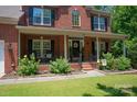 Inviting front porch with black shutters, black railing, and well-maintained landscaping at 1125 Victoria Blake Ln, Belmont, NC 28012