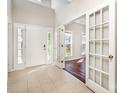 Bright foyer with tile flooring, high ceilings, and glass doors leading to an adjacent room with wood floors at 119 Tilton Dr, Mooresville, NC 28115