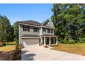 Well-maintained two-story home featuring neutral siding, a covered porch, a two-car garage, and a spacious driveway at 1227 Breezewood Dr, Charlotte, NC 28262