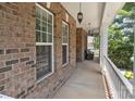 Inviting porch with brick exterior, pendant lights and comfortable seating area at 125 Snow Fountain Ln, Mooresville, NC 28115