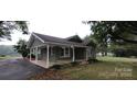 Side view of a quaint single-story home featuring a covered porch and landscaped yard at 1521 N Piedmont Ave, Kings Mountain, NC 28086