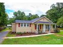 A charming single-story house with a covered porch and inviting red shutters accents the exterior at 218 Blacksnake Rd, Stanley, NC 28164