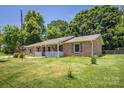 Charming brick home featuring a welcoming front porch and lush green lawn at 2526 Ashford Dr, Newton, NC 28658