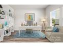 Bright home office with built-in bookshelves, a desk, and a comfortable armchair at 4046 Armstrong Farm Dr, Belmont, NC 28012