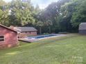 Backyard pool has mature trees, and an adjacent red outbuilding at 4050 Rollingwood Cir, Rock Hill, SC 29732