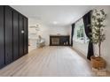 Bright living room with modern fireplace, hardwood floors, large windows, and open view to the kitchen at 5420 Gwynne Ave # 21, Charlotte, NC 28205
