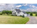 Expansive lawn and exterior view of a two-story home, complemented by lush landscaping and a detached garage at 594 Patterson Farm Rd, Mooresville, NC 28115