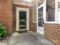Covered entrance with brick facade and storm doors, offering a welcoming approach at 8465 Olde Troon Dr, Charlotte, NC 28277