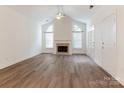 Spacious living room boasting a fireplace, high ceilings, wood floors, and large windows at 8465 Olde Troon Dr, Charlotte, NC 28277