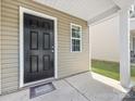 Close up of a six panel black front door with small window and a covered porch at 9136 Creedmore Hills Dr, Charlotte, NC 28214