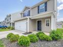 Charming two-story home with a two car garage, black front door, and landscaped yard at 9136 Creedmore Hills Dr, Charlotte, NC 28214