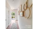 Welcoming entryway with decor, leading to an open door with natural light and a glimpse of the outdoors at 10412 Dalton Woods Nw Ct, Huntersville, NC 28078