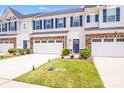 Beautiful townhome with a two car garage, stone accents, a concrete driveway, and well manicured landscaping at 10412 Dalton Woods Nw Ct, Huntersville, NC 28078