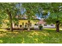 Charming home with a welcoming front porch framed by mature trees and lush landscaping at 1043 Linneys Mill Rd, Union Grove, NC 28689