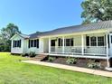 Charming one-story home featuring a welcoming front porch and meticulously landscaped walkway at 147 Dutchman Rd, Harmony, NC 28634