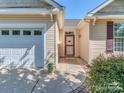 Close up of front entrance featuring a red door and adjacent garage with decorative windows at 15739 Circlegreen Dr, Charlotte, NC 28273