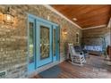 Inviting front porch features decorative front door, rocking chairs, and a porch swing at 260 River Country Rd, Salisbury, NC 28146
