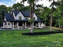 Charming two-story home featuring a welcoming front porch with rocking chairs and a well-maintained lawn at 4023 Yesteryears Ln, Marshville, NC 28103
