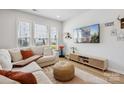 Bright living room with large windows, plush seating, and a modern entertainment center at 5008 Calvine Mill Way, Charlotte, NC 28205