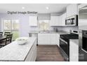 Bright kitchen features white cabinets, stainless steel appliances, and granite countertops at 5213 Crimson Kate Ln # 2007B, Charlotte, NC 28208