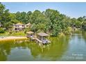 Stunning aerial view of the lakefront property with a private beach, dock, and lush surroundings at 5390 Hudson Rd, Lake Wylie, SC 29710