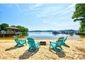 Relax on the private sandy beach with chairs and a fire pit overlooking the serene lake at 5390 Hudson Rd, Lake Wylie, SC 29710