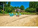 Charming home with a private beach, fire pit, and serene lake views surrounded by lush greenery at 5390 Hudson Rd, Lake Wylie, SC 29710