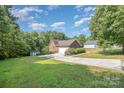 View of home's side-entry garage, paved driveway, and spacious lawn with storage shed at 610 Mountain Pl, Albemarle, NC 28001