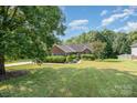 Lovely brick home with lush lawn and mature trees creating a welcoming curb appeal at 610 Mountain Pl, Albemarle, NC 28001