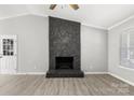 Bright living room features a ceiling fan, new floors and a stone fireplace at 6515 Santa Cruz Trl, Charlotte, NC 28227