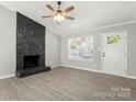 Bright living room features a ceiling fan, new floors and a stone fireplace at 6515 Santa Cruz Trl, Charlotte, NC 28227