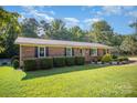 Well-maintained brick home, showcasing manicured front yard, mature trees and bright green lawn at 753 Briarfield Rd, Rock Hill, SC 29730