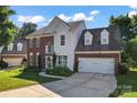 Charming brick and siding home featuring a well-manicured lawn and two-car garage at 8000 Pelorus Ln, Charlotte, NC 28269