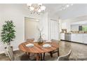 Cozy dining area with modern chandelier adjacent to the bright kitchen at 8724 Tweedsmuir Glen Ln, Charlotte, NC 28215