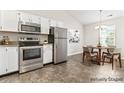 Bright kitchen features stainless steel appliances and a dining area with lots of natural light at 8724 Tweedsmuir Glen Ln, Charlotte, NC 28215