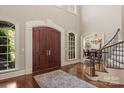 Elegant foyer with hardwood floors, a curved staircase, and a view into the formal dining room at 9110 Woodhall Lake Dr, Waxhaw, NC 28173