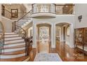 Expansive foyer with a curved staircase, iron railings, and access to multiple living spaces at 9110 Woodhall Lake Dr, Waxhaw, NC 28173