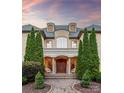 Grand entrance featuring a covered porch with columns, double doors, and manicured greenery at 9110 Woodhall Lake Dr, Waxhaw, NC 28173