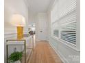 Bright hallway with wainscoting, light wood floors, modern decor, and a window bringing in natural light at 1517 Falcon St, Charlotte, NC 28211