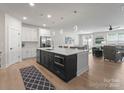 Open-concept kitchen featuring a large island with seating, stainless steel appliances, and an open view to the living room at 1517 Falcon St, Charlotte, NC 28211