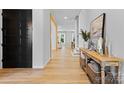 Open concept foyer with hardwood floors, stylish console table, and view of living room and dining area at 18027 Wilbanks Dr, Charlotte, NC 28278