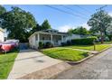 Charming home with a cozy front porch and a lush green lawn, complemented by a paved driveway at 215 Cedar St, Belmont, NC 28012