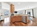 Modern kitchen featuring stainless steel dishwasher and sink, granite countertops, and open view into dining and living room at 2203 Whitford Ln, Charlotte, NC 28210