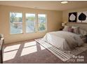 Bright main bedroom featuring large windows and neutral tones at 2440 Mint Thistle Ct, Charlotte, NC 28269
