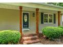 Covered front porch with decorative columns and brick steps leading to a stylish front door at 267 Winthrow Creek Rd, Mooresville, NC 28115