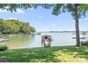 Picturesque waterfront view with a dock and lush green lawn extending to the water's edge at 2704 Apache Trl, Denver, NC 28037
