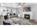 Comfortable living room featuring a fireplace, ceiling fan, and neutral decor with ample natural light at 3705 Chesapeake Pl, Waxhaw, NC 28173
