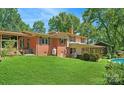 Manicured backyard featuring lush green grass, mature trees, and glimpses of a refreshing swimming pool, perfect for outdoor relaxation at 408 E Blume St, Landis, NC 28088