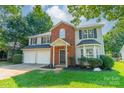 Two-story home featuring a front lawn, two car garage, and a welcoming entrance at 4230 Chatterleigh Dr, Monroe, NC 28110